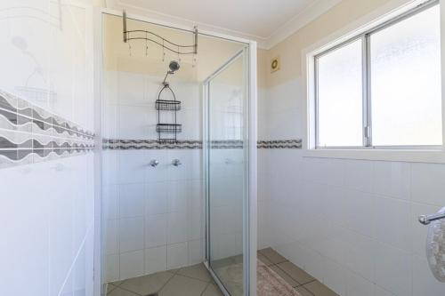 a shower with a glass door in a bathroom at Unbeatable Waterfront Location in Sussex Inlet
