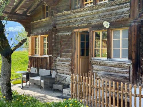 a wooden house with a bench and a table outside at 3-Bedrooms Apartment in a Chalet in Meiringen