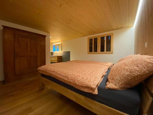 a bedroom with a bed with a wooden ceiling at 3-Bedrooms Apartment in a Chalet in Meiringen