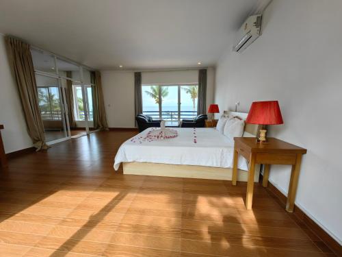 May Beach Resort في جزيرة كوه رونغ: غرفة نوم بسرير وطاولة مع مصباح