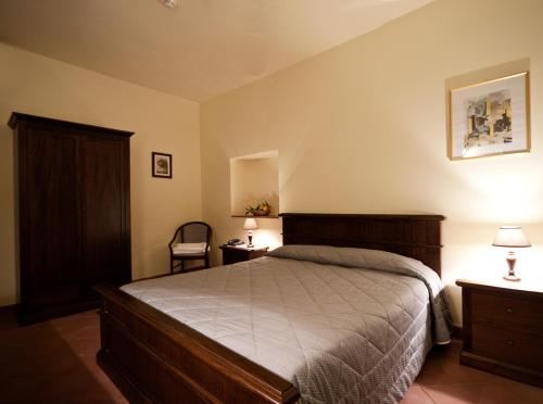 a bedroom with a bed and two tables and a chair at La Terra Del Mezzo in Riposto