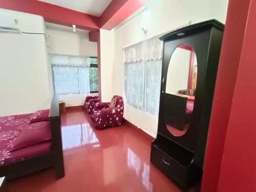 a room with a tv and a bed and a mirror at Benjamin homestay in Mawlynnong