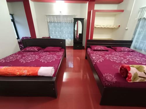 two beds in a room with purple sheets at Benjamin homestay in Mawlynnong