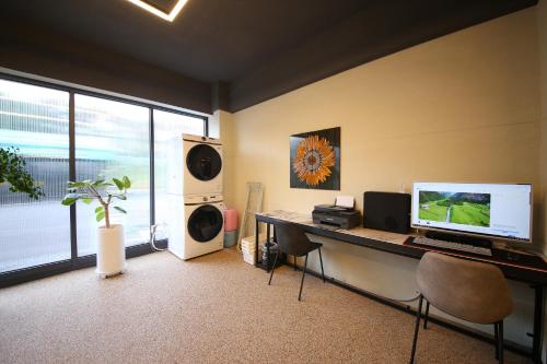 a room with a desk with a computer and speakers at Brown Dot Hotel Sinan in Gwangju