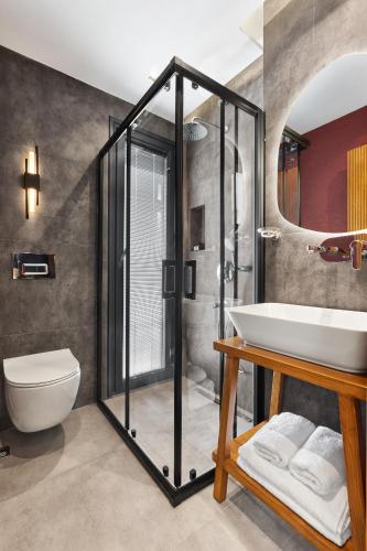 a bathroom with a shower and a sink and a toilet at Meruno Alaçatı in Çeşme