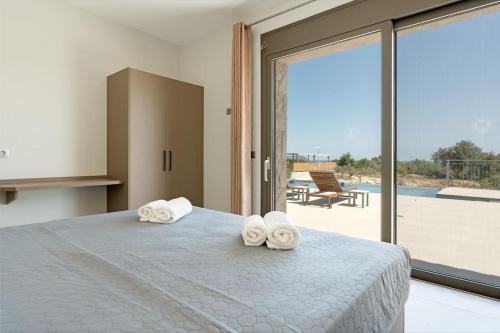 a bedroom with a bed with towels on it at Brand New: Kefalonia Stone Villas - Villa Trapezaki Retreat in Trapezaki