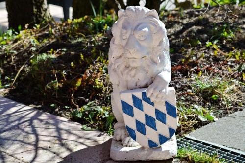 a statue of a lion holding a shield at BayernBlick in Rimsting