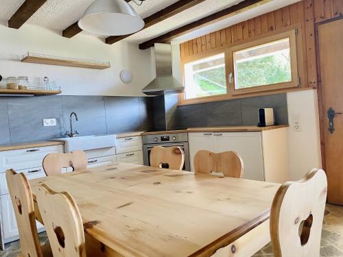 a kitchen with a wooden table and chairs in it at Eco Lodge with Jacuzzi and View in the Swiss Alps in Grône
