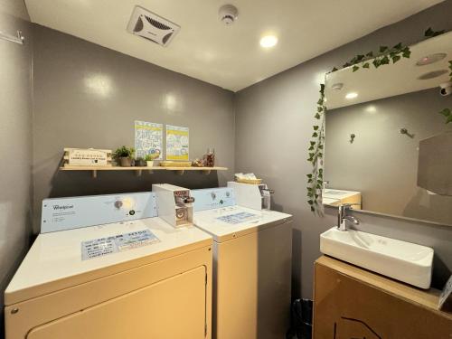 a laundry room with a sink and a mirror at Chaiin Hotel - Dongmen in Taipei