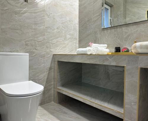 a bathroom with a toilet and a counter with towels at Vila Anda in Eforie Sud