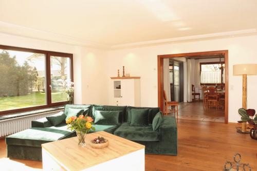 uma sala de estar com um sofá verde e uma mesa em ChiemseeZeit em Gstadt am Chiemsee