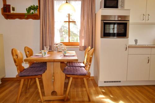 een keuken met een houten tafel met stoelen bij Ferienresidenz Chiemseestrand - Apartment 28 in Chieming
