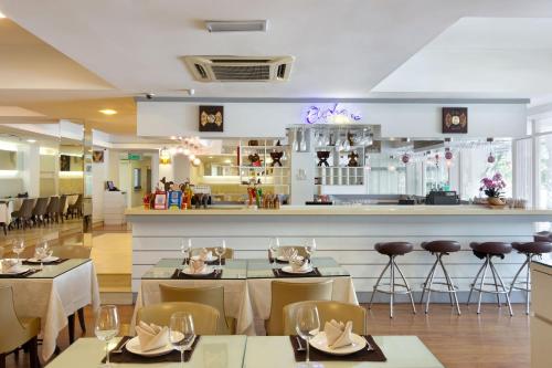 een restaurant met tafels en stoelen en een bar bij Kings Hotel Melaka in Melaka