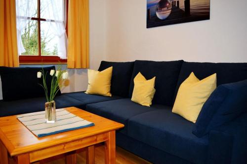 een woonkamer met een blauwe bank en gele kussens bij Ferienresidenz Chiemseestrand - Chiemseesonne in Chieming