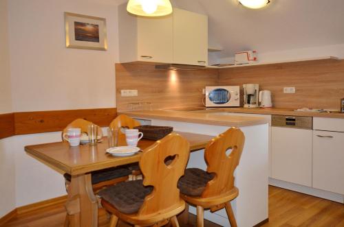 a small kitchen with a wooden table and chairs at Ferienresidenz Chiemseestrand - Apartment 31 in Chieming