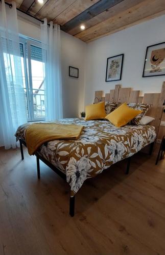 1 dormitorio con 1 cama grande con almohadas amarillas en Gite & Spa Au pommier fleuri et son "Appart" indépendant, en Drusenheim