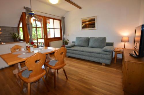 ein Wohnzimmer mit einem Tisch, Stühlen und einem Sofa in der Unterkunft Ferienresidenz Chiemseestrand - Sunset 17 in Chieming