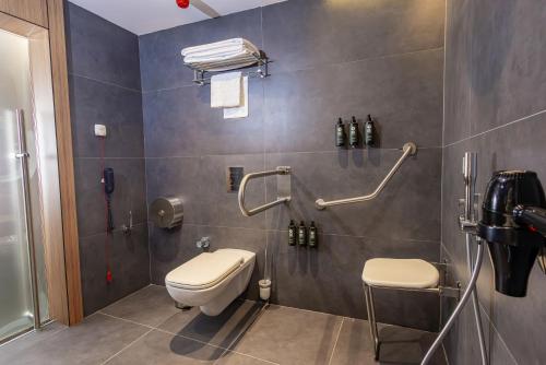 a bathroom with a toilet and a shower at FT Lotus Thermal Hotel&SPA Trademark Collection by Wyndham in Menemen