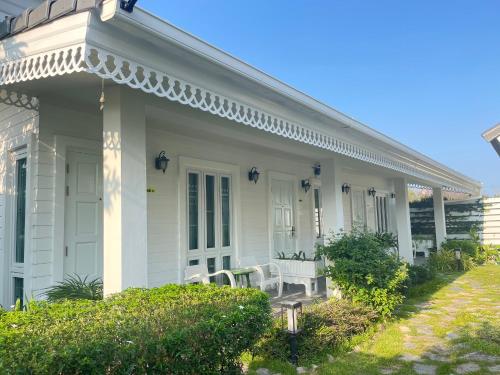 a white house with a table and chairs on the porch at Pailin Pool Villa,HuaHin in Hua Hin