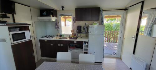a small kitchen with a sink and a refrigerator at Mobilhome 6 personnes in Parentis-en-Born