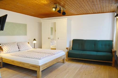 - une chambre avec un lit et un canapé bleu dans l'établissement Möderlhof - König Ludwig, à Eggstätt