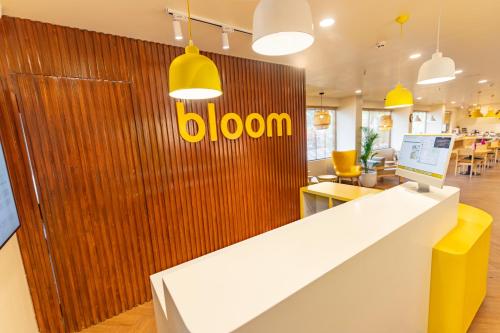 een kantoor met een geel bord op een houten muur bij Bloom Hotel - Richmond Road in Bangalore
