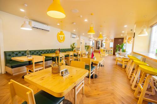 a restaurant with wooden tables and yellow chairs at Bloom Hotel - Richmond Road in Bengaluru