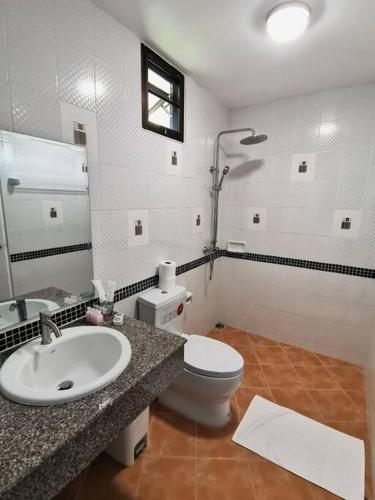 a bathroom with a sink and a toilet and a mirror at Kata beach townhouse in Kata Beach