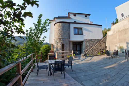 a patio with a table and chairs and a building at Urocza Art Pensjonat in Krynica Zdrój