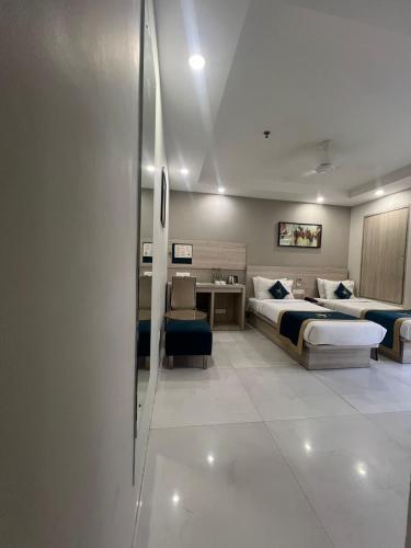 a hotel room with two beds and a desk at Sparrow Hotel Managed by Siara Sariska Alwar in Alwar