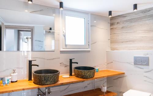 two sinks on a counter in a bathroom at Gtrip Gazi Duplex Apartment - 33701 in Athens