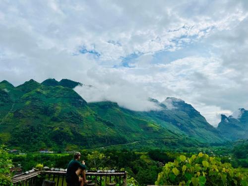 a man flying a kite in front of a mountain at Tày Cốc Pảng Homestay in Làng Cac