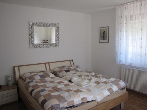 een bed in een slaapkamer met een spiegel aan de muur bij Feriendomizil Weinheim in Gorxheim