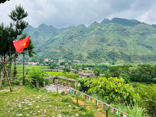 una bandera roja en una colina con montañas en el fondo en Du Già Coffee View Homestay en Làng Cac