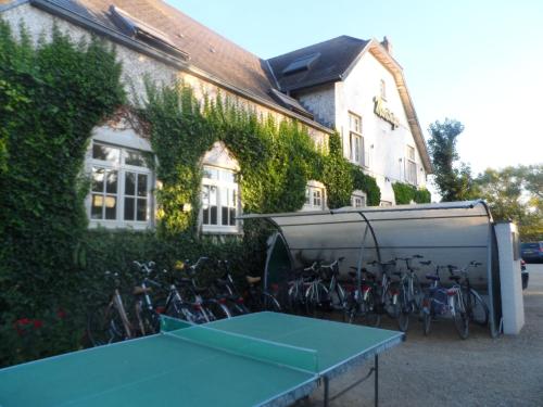 a ping pong table in front of a building with bikes at Hotel Martinique in Nieuwpoort