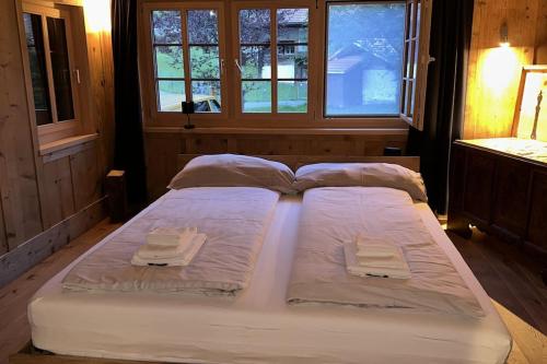 a large bed with white sheets and towels on it at 5 Bedrooms Chalet Brünig in Meiringen