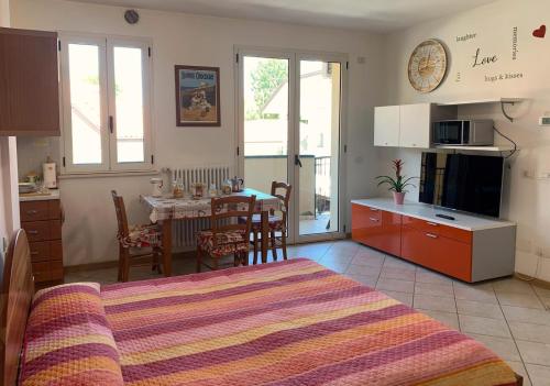 sypialnia z łóżkiem oraz kuchnia ze stołem w obiekcie Marechiaro w Rimini