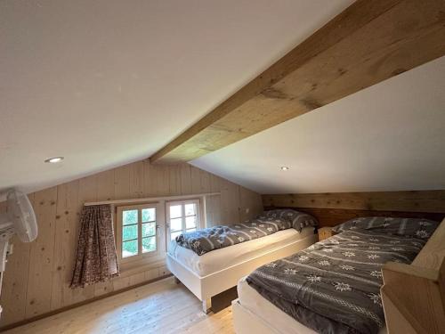 a attic bedroom with two beds and a window at 5 Bedrooms Chalet Brünig in Meiringen