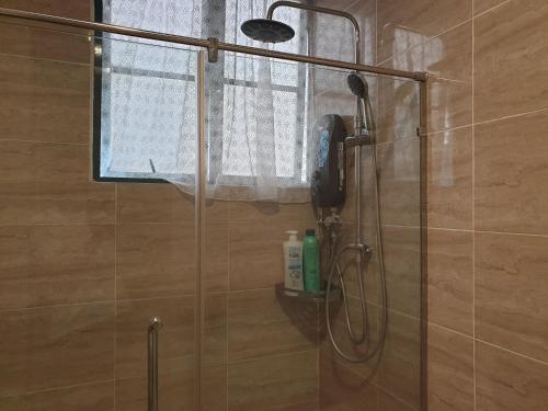 a shower with a phone on a glass door at 1Bedroom Urban Oasis Retreat in Melaka