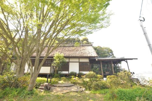 a small house with a tree in front of it at Hokyuann - 邦久庵 in Motogoe