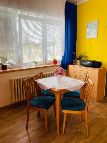 a dining room table with chairs and a table with flowers on it at Apartmán Voletínská 255 in Trutnov