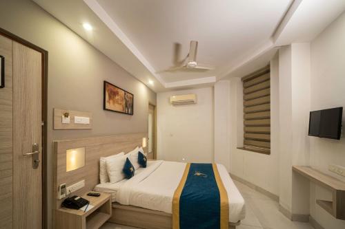 a hotel room with a bed and a television at Sparrow Hotel Managed by Siara Sariska Alwar in Alwar