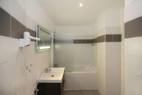 une salle de bain blanche avec un lavabo et une baignoire dans l'établissement 106- Appartement lumineux face jardins des Plantes - FLAT-GUEST, à Paris