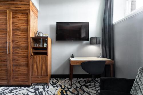 a room with a desk and a tv on a wall at Home Hotel Katajanokka in Helsinki