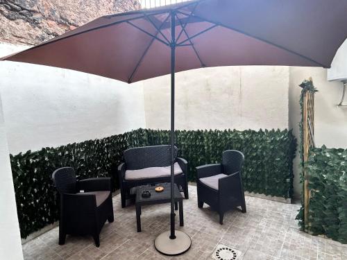a table and chairs under an umbrella in a patio at Al piccolo borgo in Catania