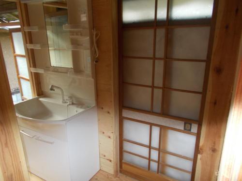 ein Bad mit einem Waschbecken und einem Spiegel in der Unterkunft SDGs house without bath & shower room - Vacation STAY 34864v in Yufu