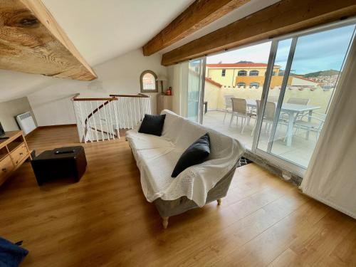 un salon avec un canapé blanc et une table dans l'établissement Cote Vermeille - Maison climatisée avec Wifi, à Banyuls-sur-Mer