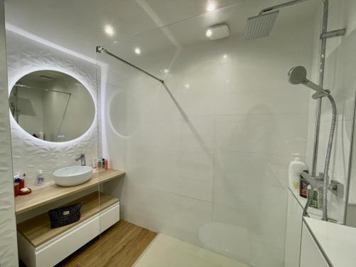 une salle de bain blanche avec une douche et un lavabo dans l'établissement Cote Vermeille - Maison climatisée avec Wifi, à Banyuls-sur-Mer