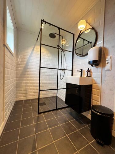 a bathroom with a shower and a sink at Segelsund Boutique Gjestehus in Holvik