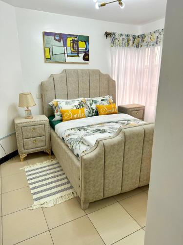a bed with orange pillows in a room at Cozy Retreat Near Nairobi National Park, Giraffe Centre & Wilson Airport in Nairobi